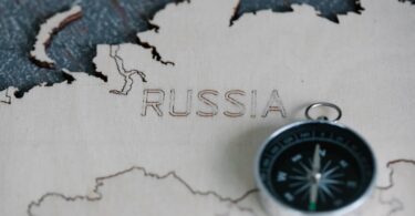 Wooden map of Russia with a compass, highlighting travel and navigation.