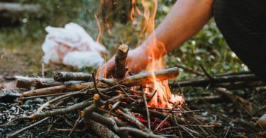 A close-up of a campfire with burning sticks. Perfect for outdoor camping themes.