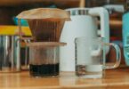 Close-up of a pour over coffee setup with water in a glass, emphasizing home brewing methods.